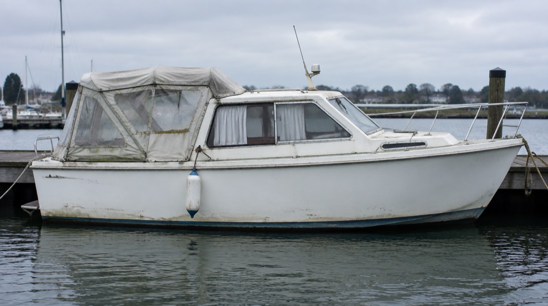 Older white hulled electric harbour cruiser showing light wear